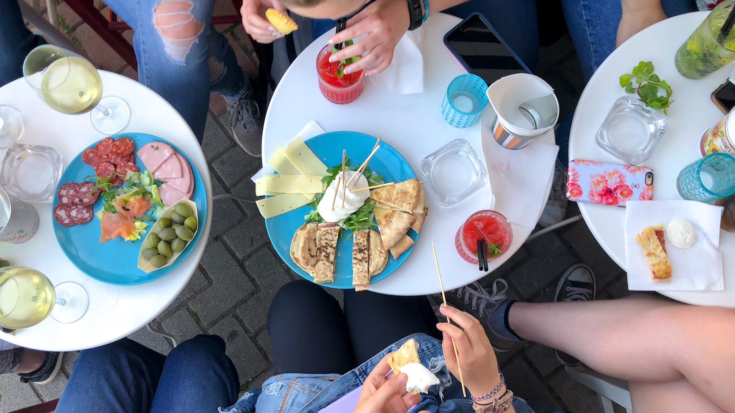 A group shares plates of aperitivo food and drinks at Al Racanà in Fano. Photo by Krishaun Burns.