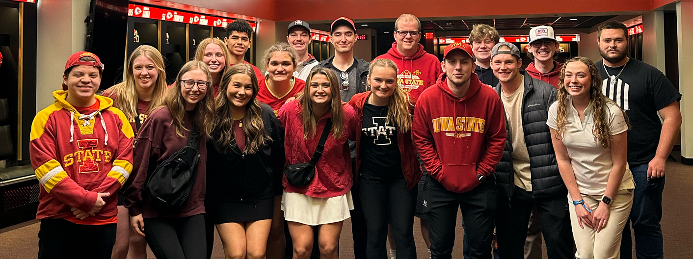 A group of students pose in the Kansas City Chiefs locker room