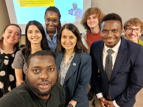 Group of students and speaker take a group selfie. 