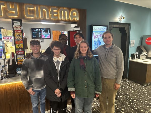 Group photo of Screenwriting Club members posing outside Varsity Cinema in Des Moines.